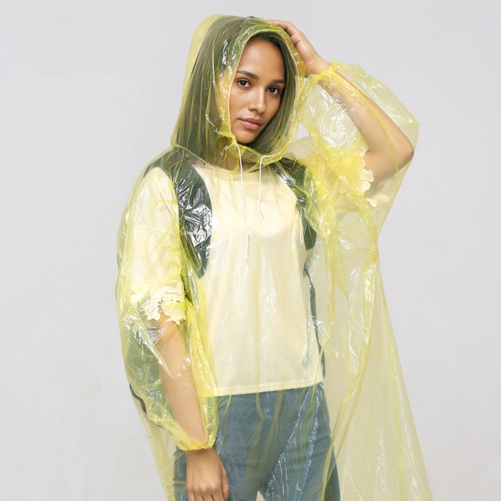 Adult disposable PE rain poncho worn over a backpack for theme park emergency stock